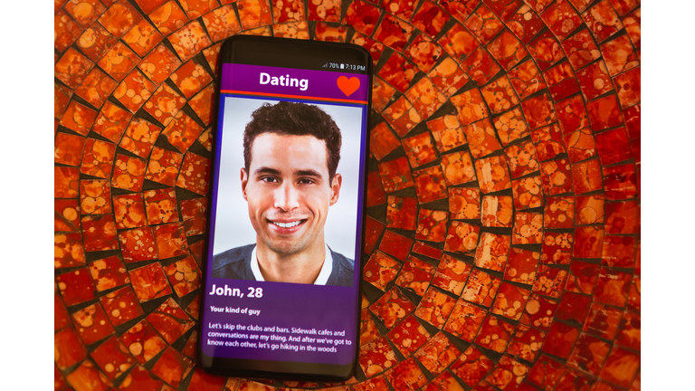 Smiling young man on mobile phone dating app
