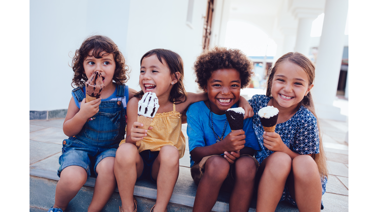 Group of cheerful multi-ethnic children eating ice-cream in summer