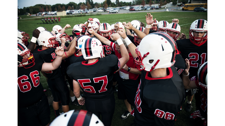 High angle view of male American football team cheering on field