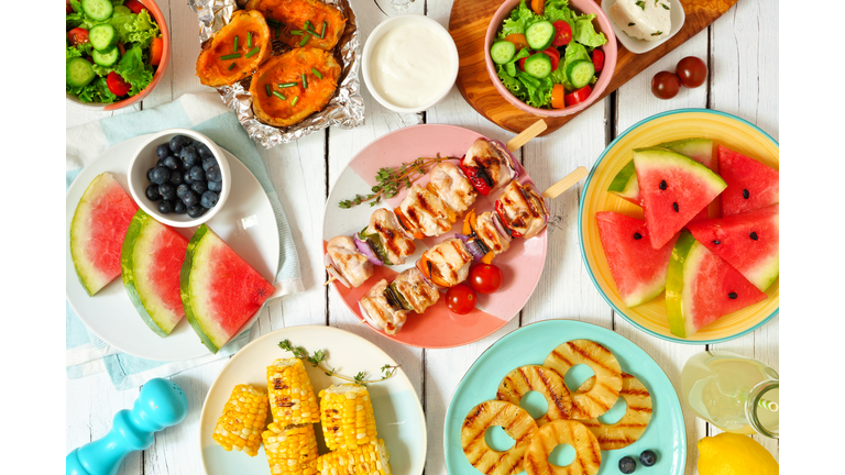 Summer BBQ or picnic food flat lay table scene over white wood