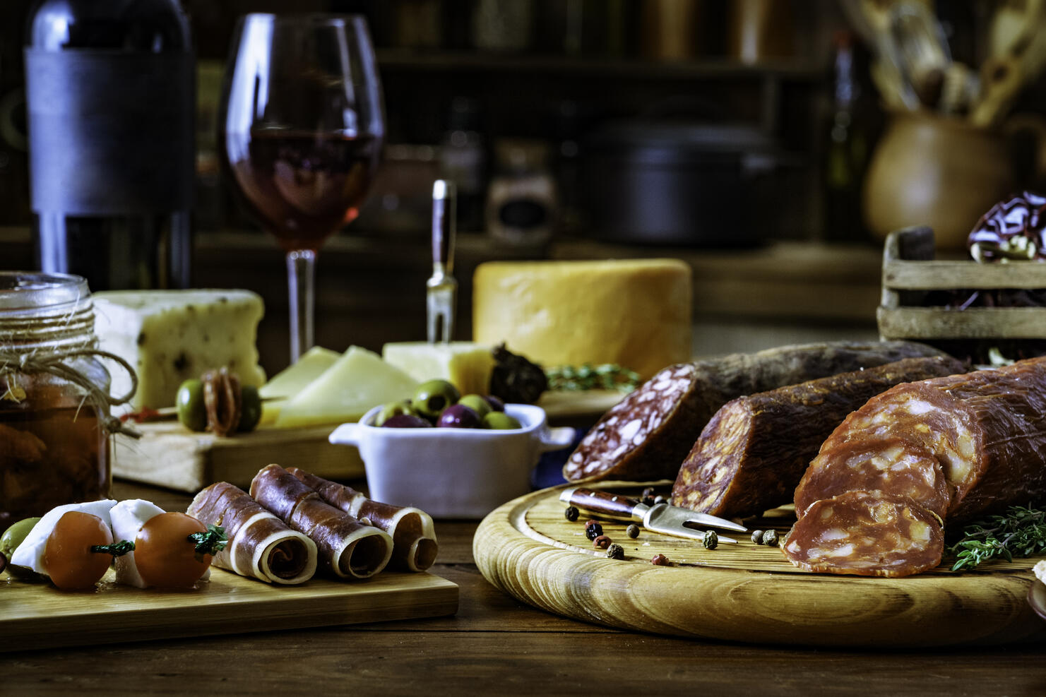 Tapas of cheese, cured ham, salami wine and chorizo on a rustic wooden table
