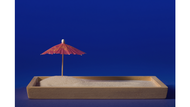 Close-up of a drink umbrella on a sandbox