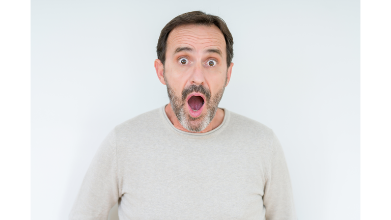 Elegant senior man over isolated background afraid and shocked with surprise expression, fear and excited face.