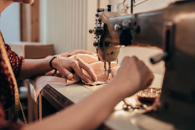Tailor working with sewing machine.