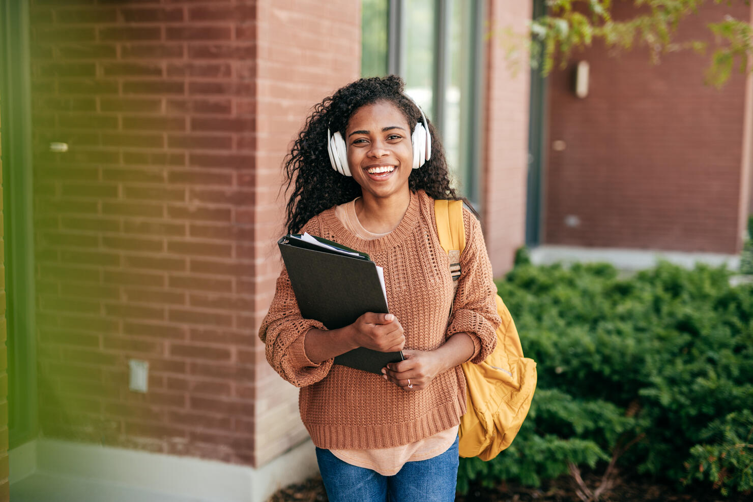 College student with headphones and folders