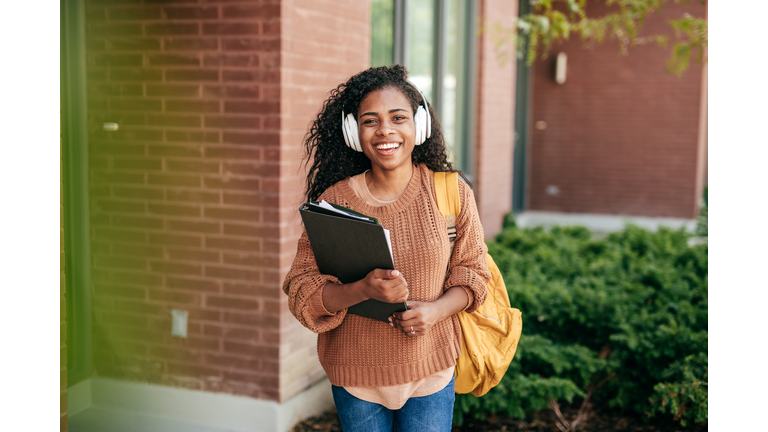 College student with headphones and folders