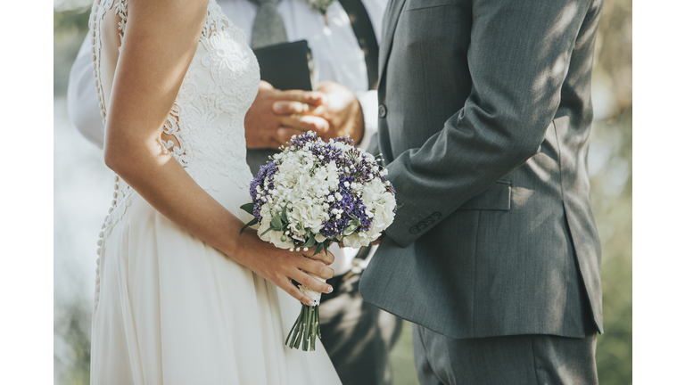 Bride and Groom Saying Vows during Wedding Ceremony Outdoors