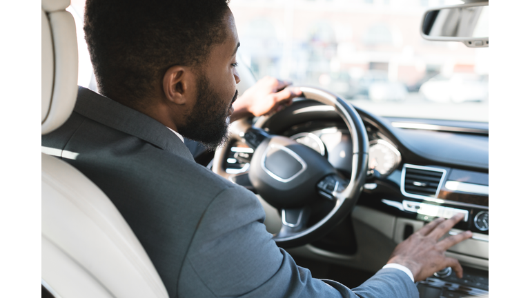 Driving with comfort. Businessman touching dashboard in car