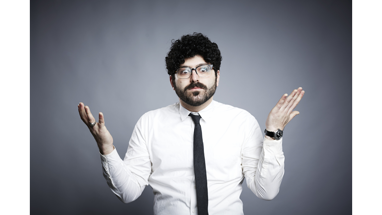 Portrait of young man, hands open in questioning expression