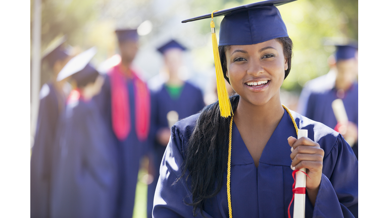 Smiling graduate holding diploma