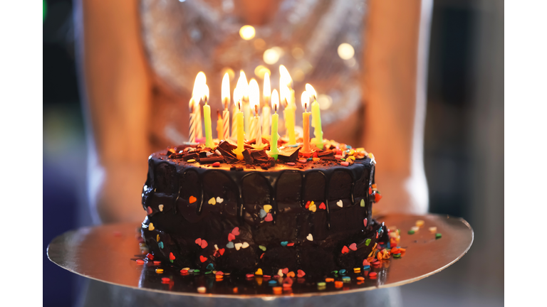 Young woman with birthday cake, closeup