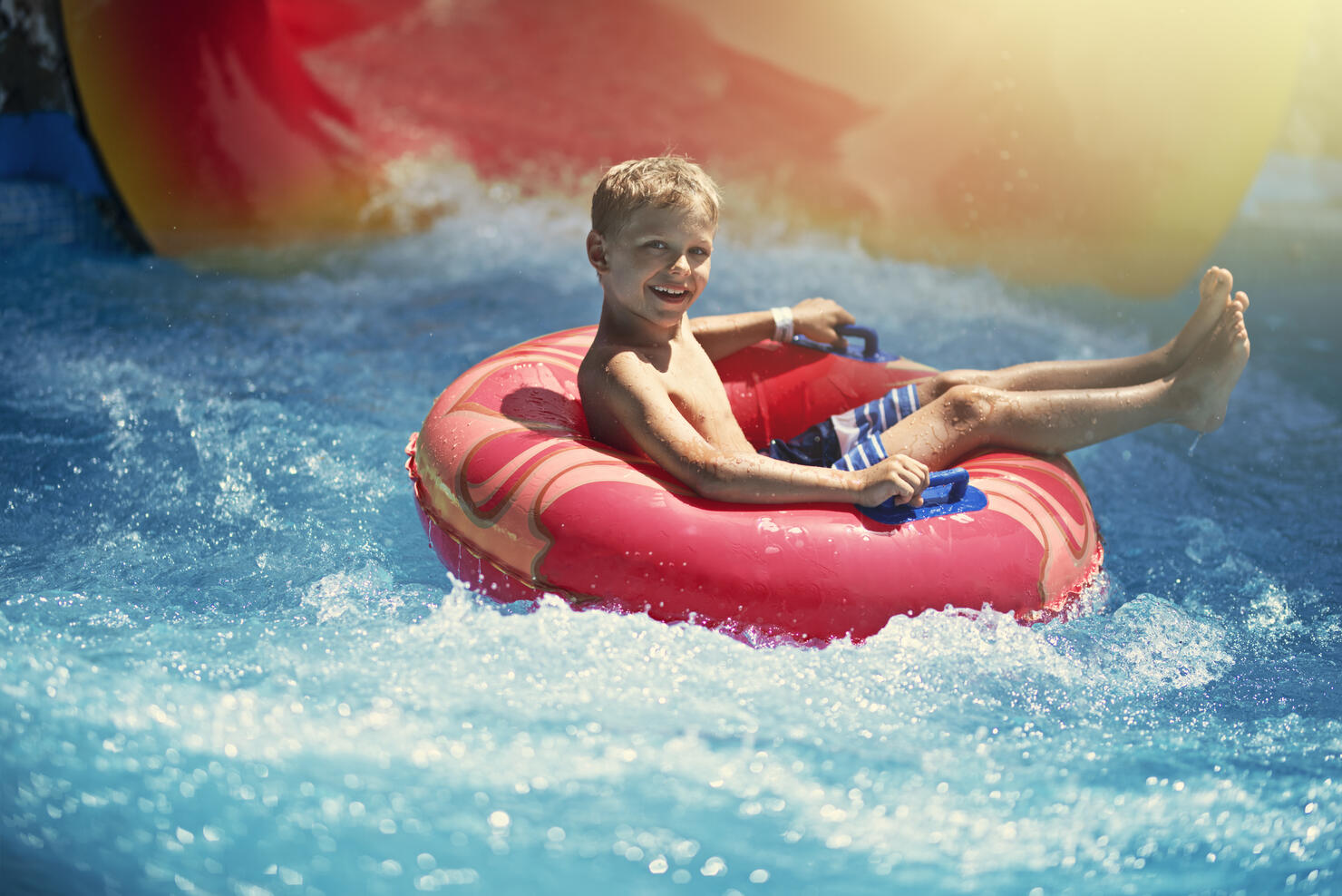 Little boy enjoying water slide in waterpark