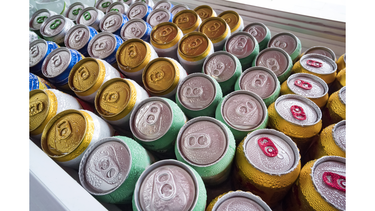 Beer cans Fresh from the fridge. Lots of aluminum cans in the ice in the open fridge. Drops of water on a cold can of drink