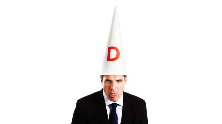 Businessman in dunce cap looking really dumb
