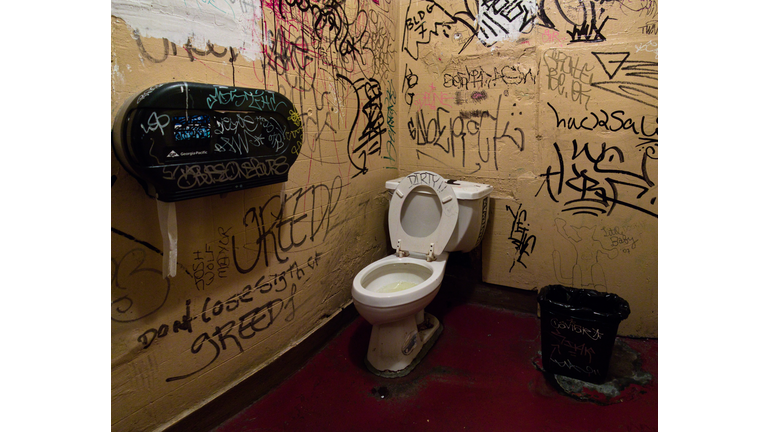 Public toilet with graffiti on wall