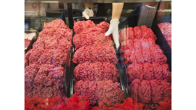 Hispanic butcher at meat counter of grocery store