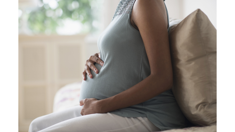 Pregnant African American mother holding her stomach