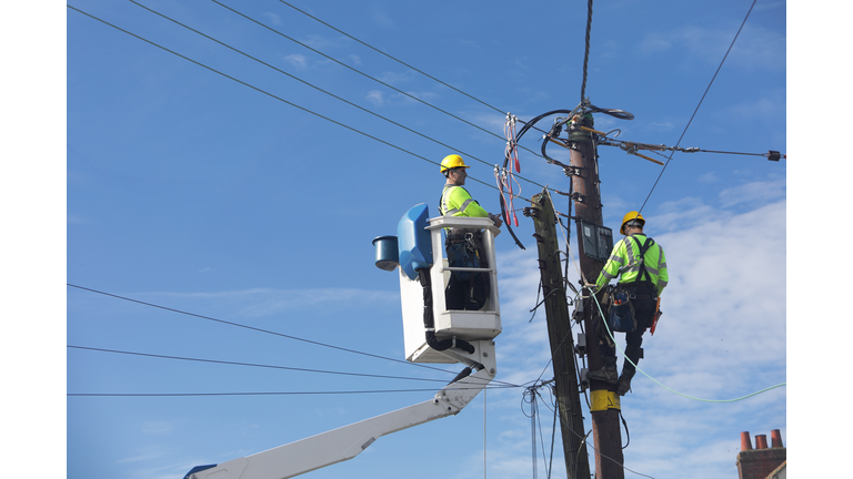 Men up pole working on power lines