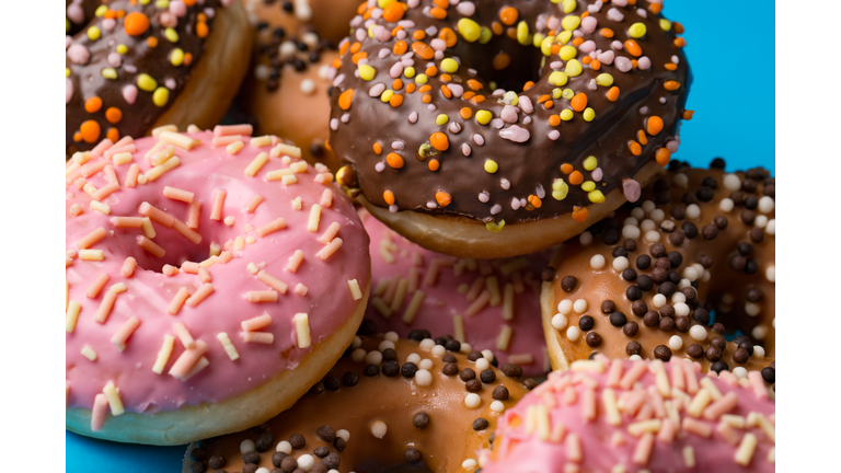assorted donuts with chocolate frosted, pink glazed and sprinkles donuts.