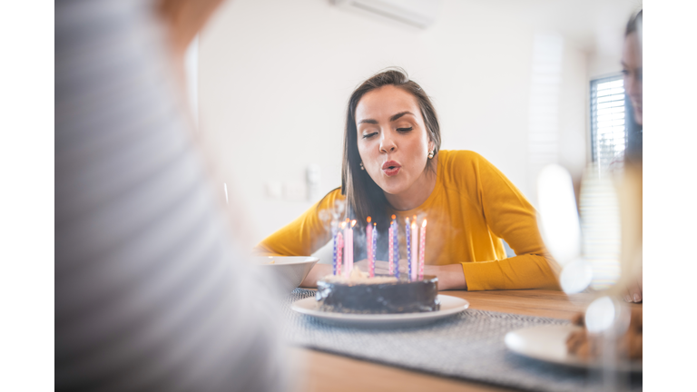 Beautiful woman blowing candles on birthday cake