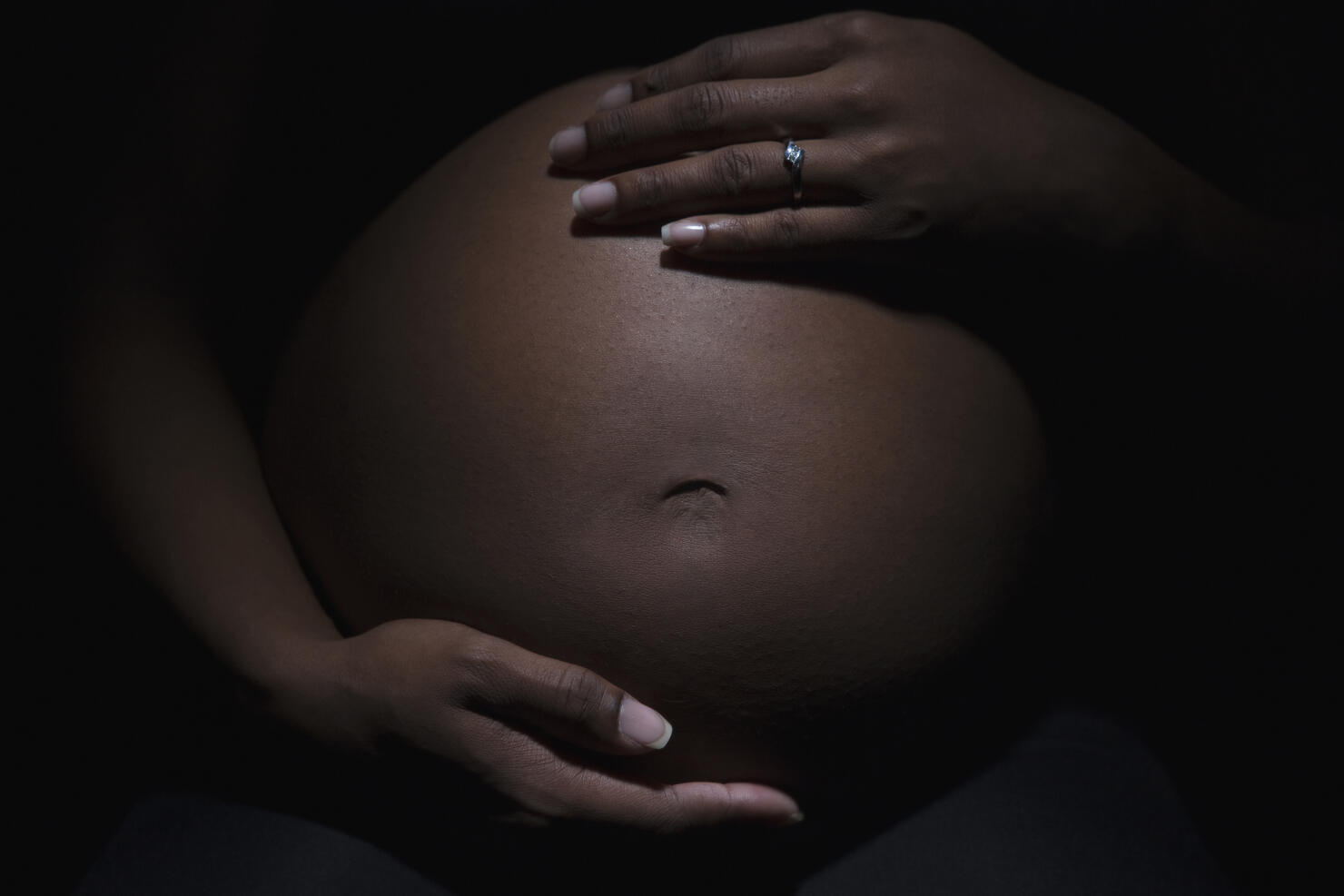 Close up of mixed race woman's pregnant stomach