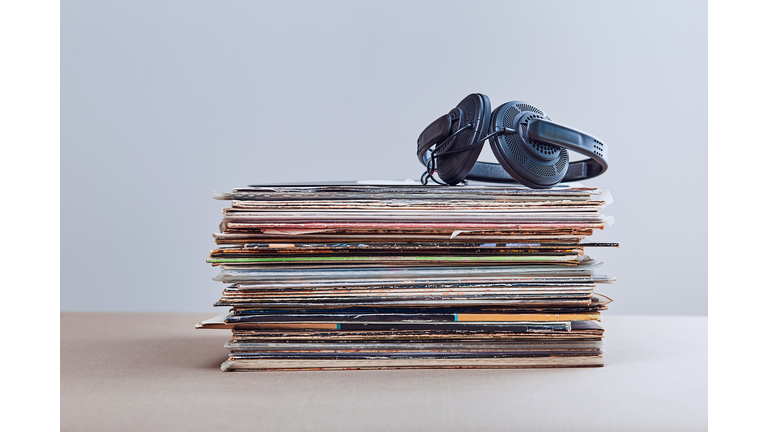 Close-Up Of Headphones On Records At Table Against Gray Background