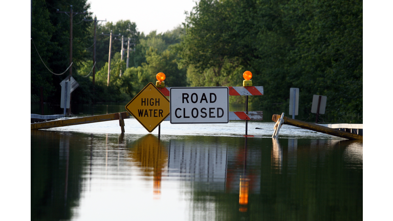 A road closure signage as water covers the road