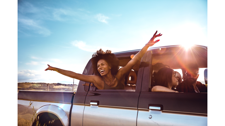 Young friends enjoying the freedom on a Car Trip over a country offroad