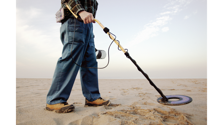 Man using metal detector at beach