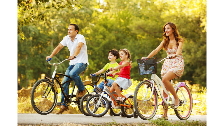 Happy Family Riding Bicycles Outdoors