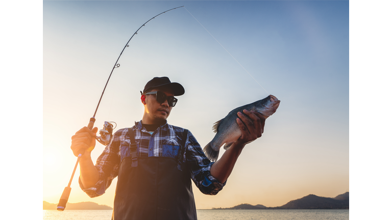 Fisherman holding big fish.