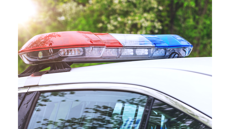 Police patrol car with sirens off during a traffic control. Blue and red flashing sirens of police car during the roadblock in the city.