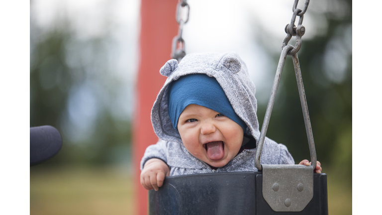 Cropped view of happy baby on swing at park