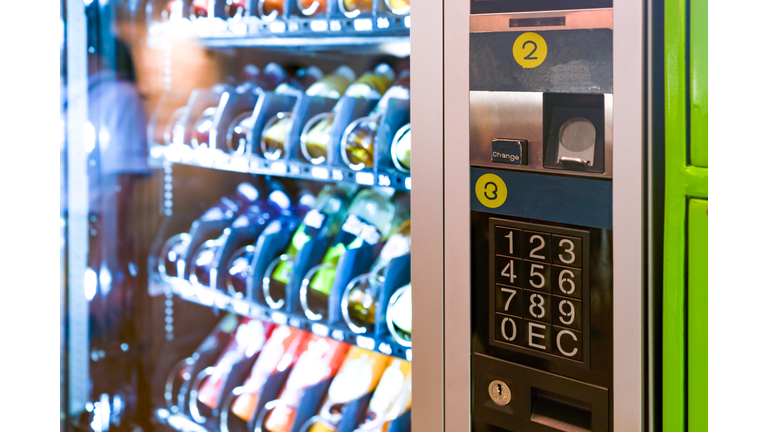 sell, technology and consumption concept - pushing button on vending machine operation panel