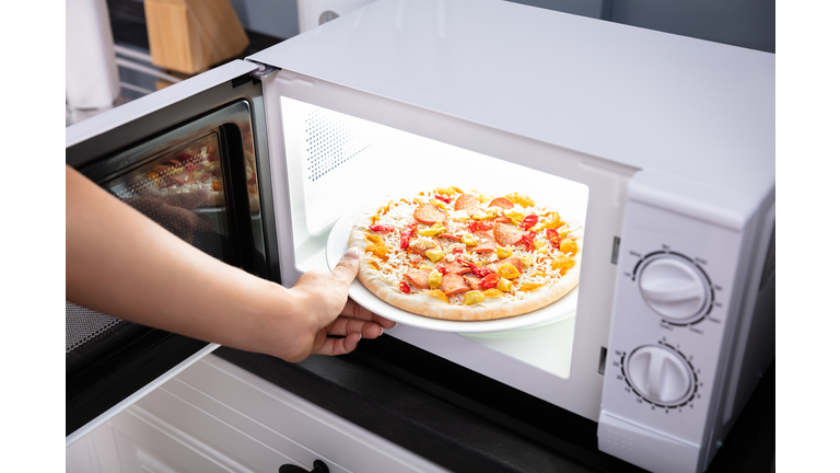 Woman Baking Pizza In Microwave Oven
