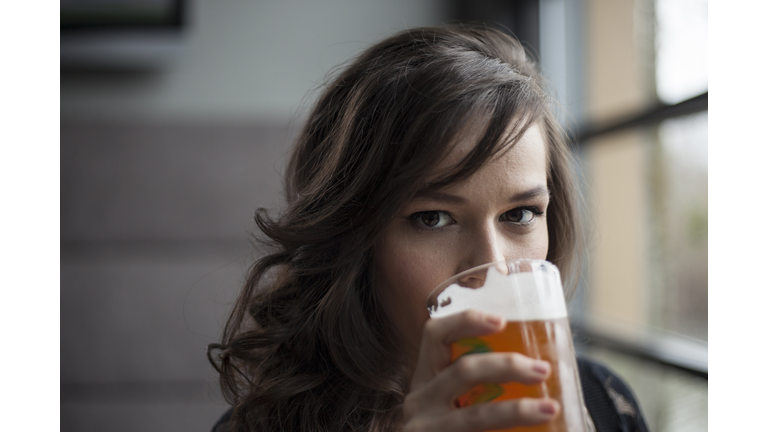 Young Woman Drinking a Pint Glass of Pale Ale