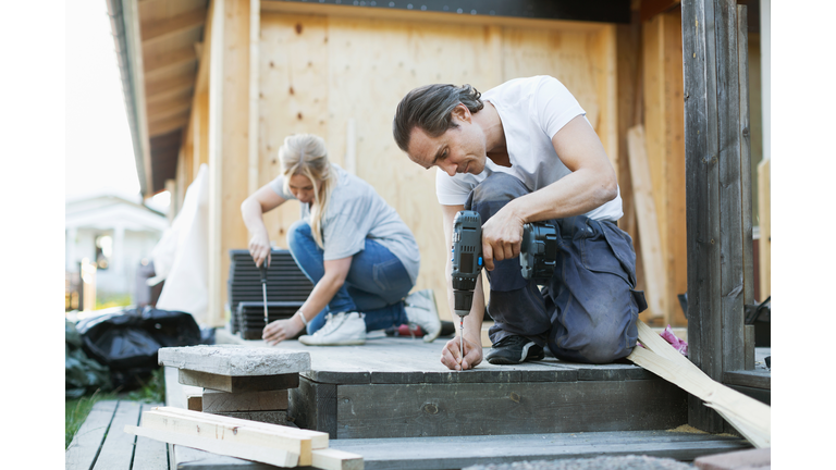 Couple working outside house during home improvement