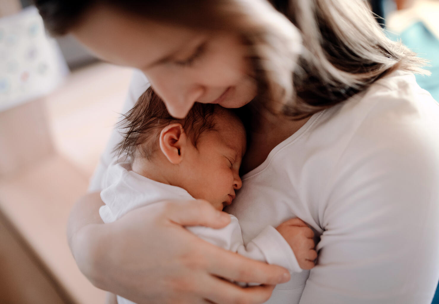 A close-up of a mother holding a newborn baby son at home.