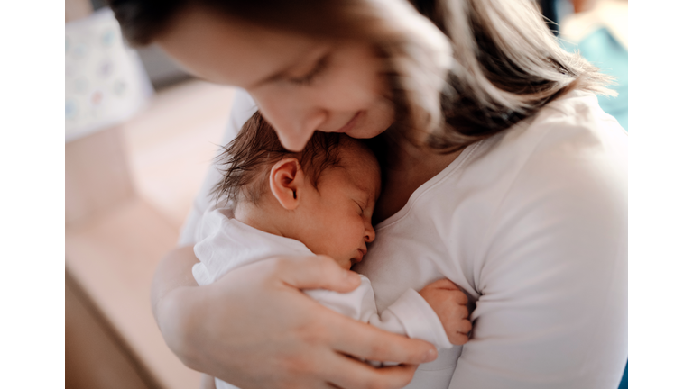 A close-up of a mother holding a newborn baby son at home.
