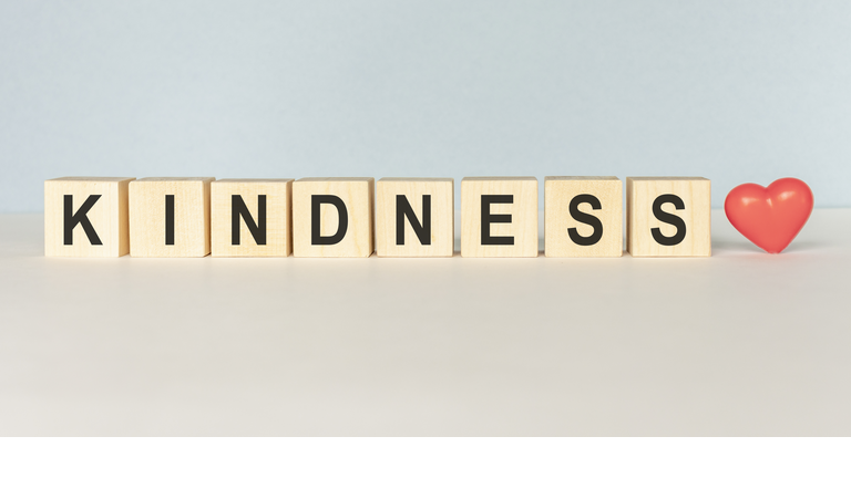 Kindness Word Written In Wooden Cube on a light background