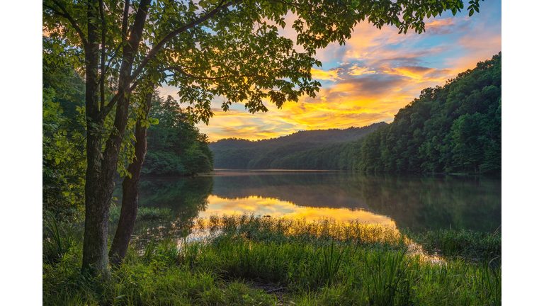 Scenic summer sunset over calm mountain lake