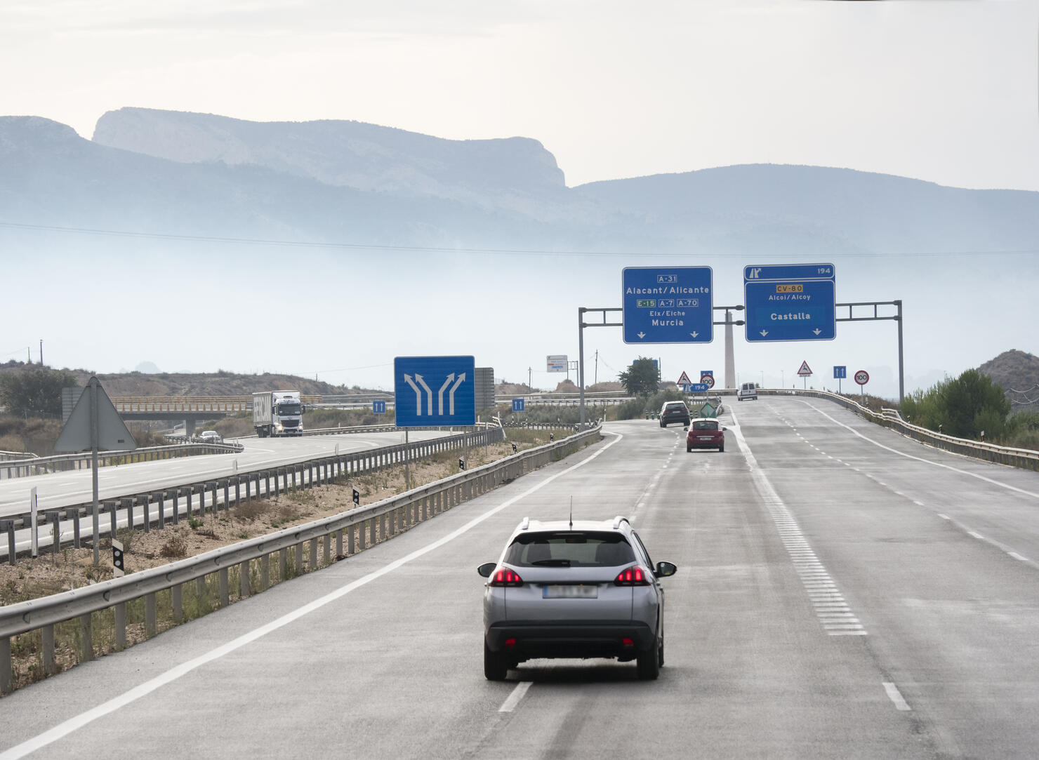 Vehicles that move in a highway of several rails during a rainy day in the morning. Highway A 7 - E 15, Spain, Europe