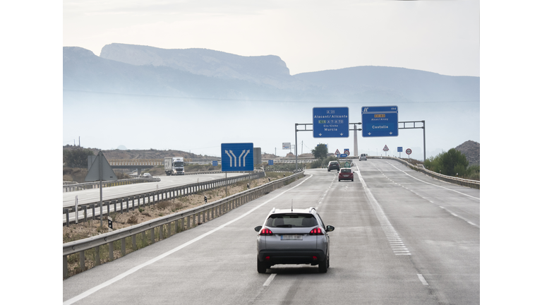 Vehicles that move in a highway of several rails during a rainy day in the morning. Highway A 7 - E 15, Spain, Europe