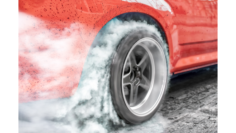 Drag racing car burns rubber off its tires in preparation for the race
