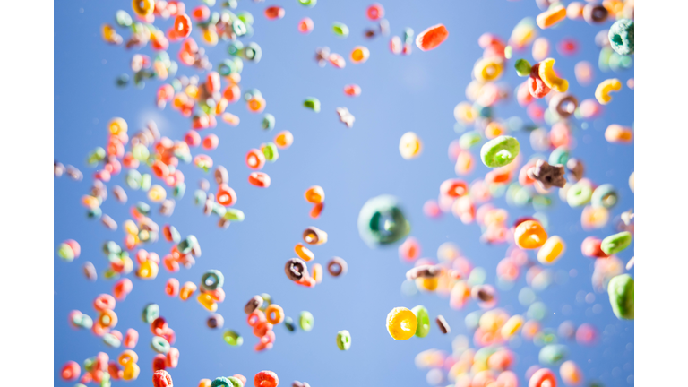 Colorful fruit loops cereals levitating in the sky in a beautiful visual effect.
