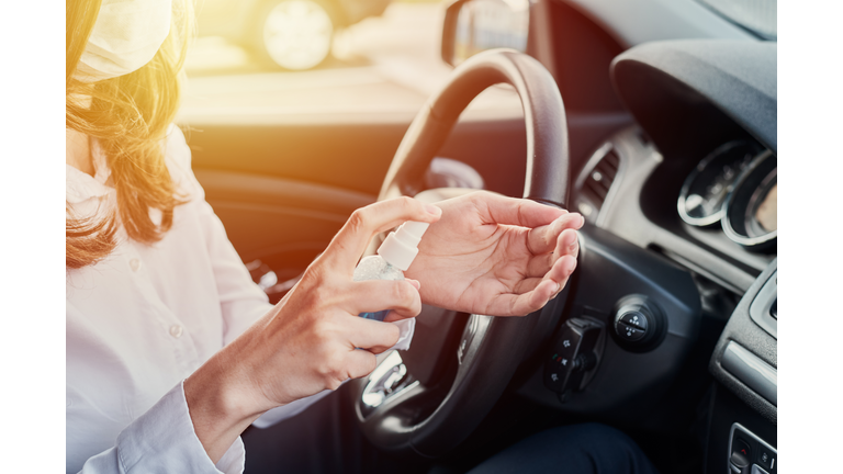 Driver disinfection hands with antibacterial sanitizer in the car before driving. Coronavirus preventative measure