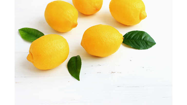 yellow lemons on white wooden background