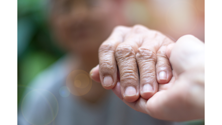 Caregiver, carer hand holding elder hand woman in hospice care. Philanthropy kindness to disabled concept.Public Service Recognition Week