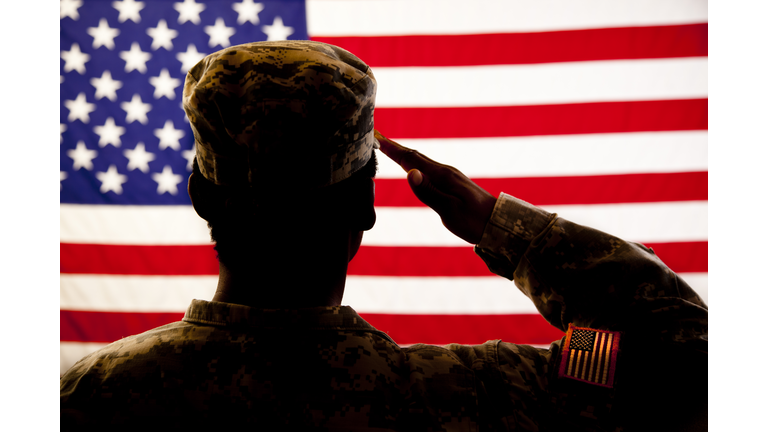 Silhouette of soldier saluting the American flag