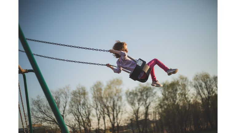 Girl swinging high into the sky